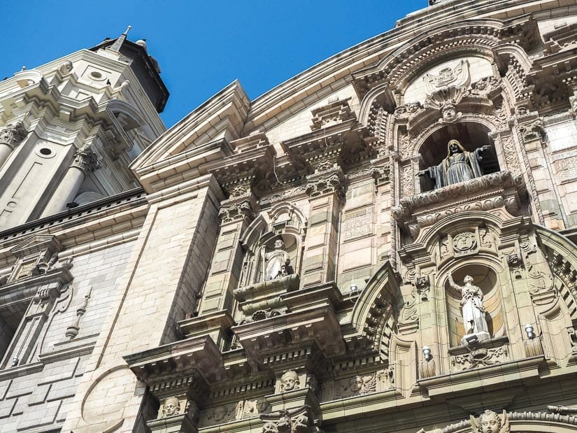Looking up at a tower and facade of the Lima Cathedral