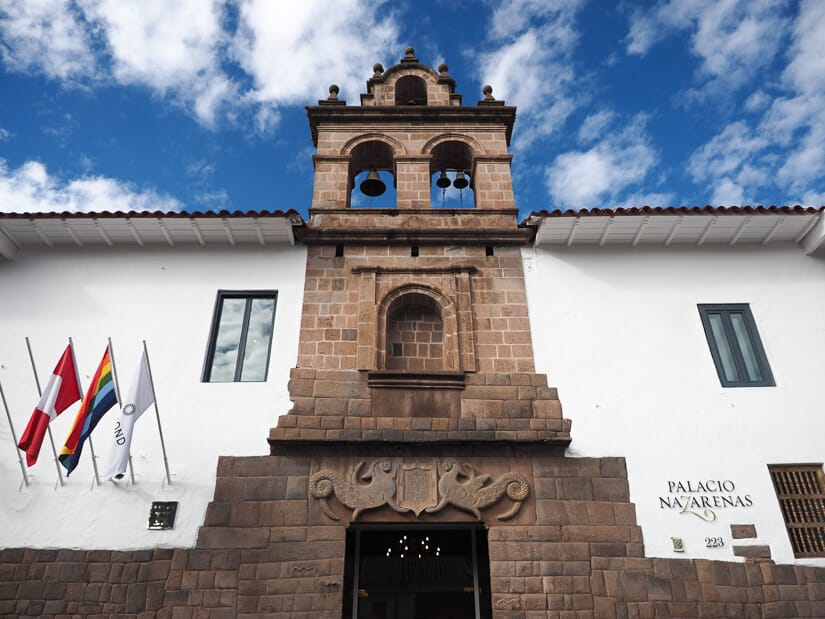 Exterior and entrance of the white and stone Museo de Arte Precolombino with flags on the side