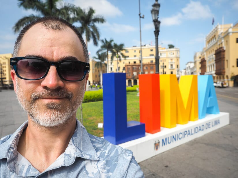 Selfie of Nick Kembel with colorful LIMA sign behind him