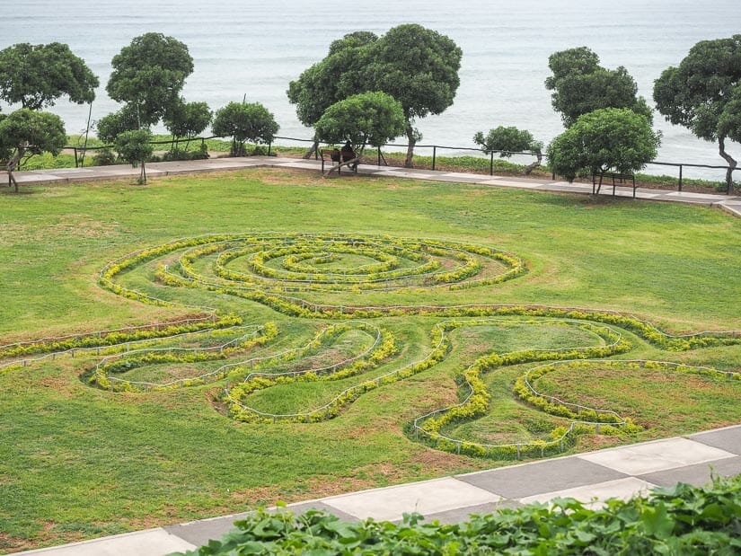 Designs in the grass that look like Nazca lines at Parque María Reiche in Lima, with ocean in background