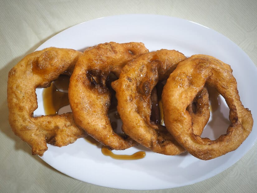 A white plate with four picarones on it