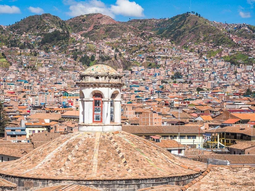 A round church top and rooftops of Cusco viewed from above