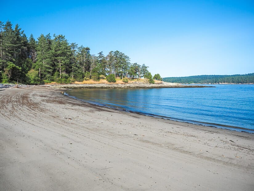 A long stretch of gray sand in a bay on Galiano Island