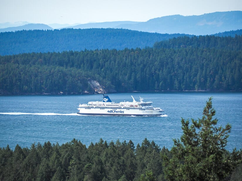 A large ferry passing between two islands