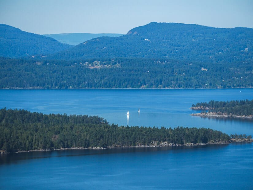 Some sailboats cruising between islands on the coast of BC