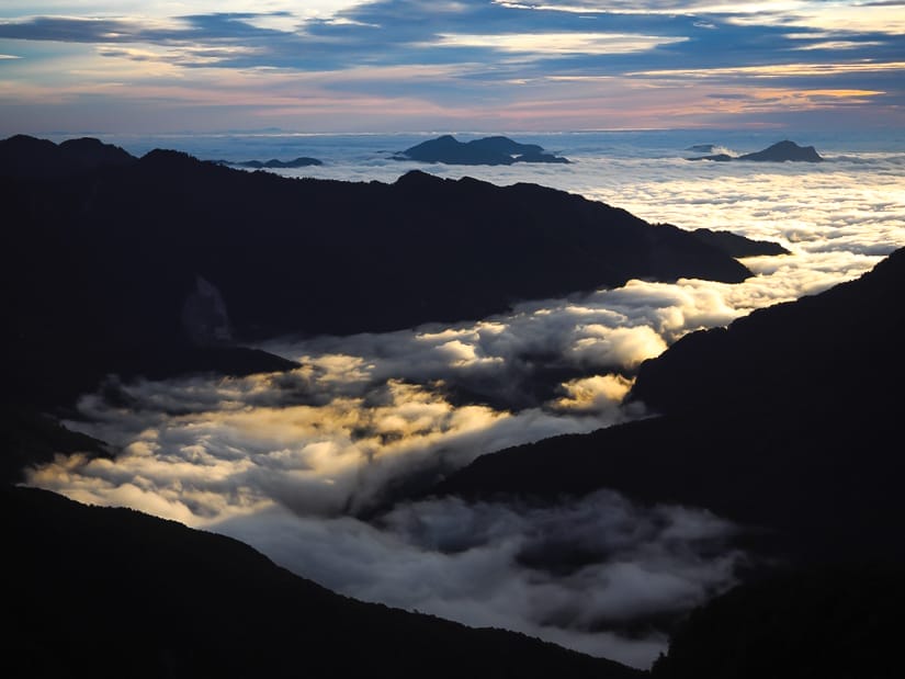 Looking down at a valley filled with a sea of clouds at sunrise