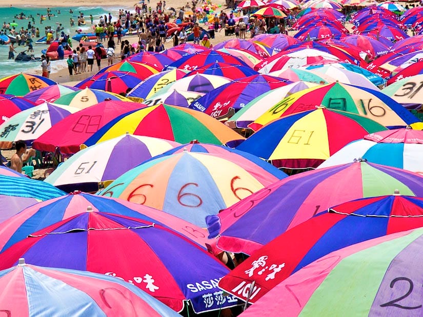 A densely crowded beach in Kenting with a sea of colorful beach umbrellas