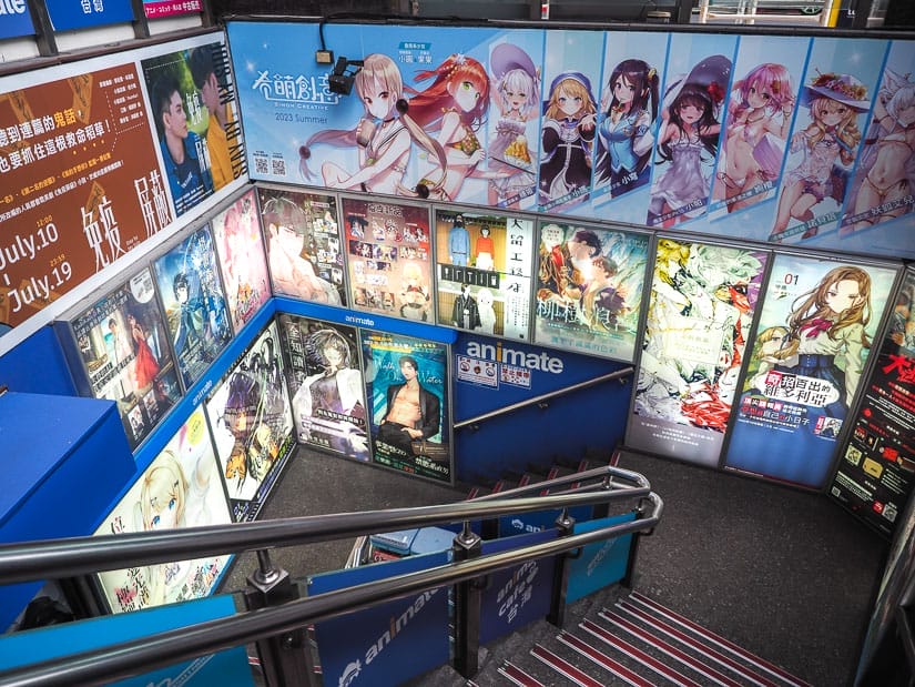 Looking down a staircase to an amime store with anime posters on the walls