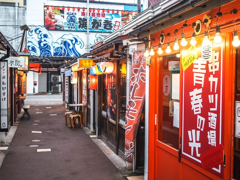 Looking up a narrow street in Hakodate Japan with some small restaurants with hanging lights in front of them
