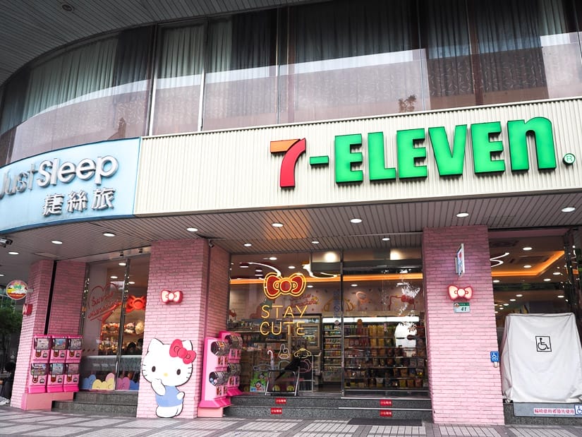Exterior of a 7-Eleven with pink walls and Hello Kitty signs on it