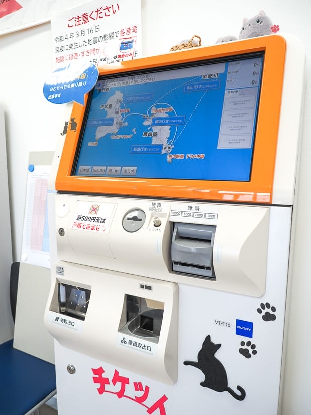 A machine for buying tickets to Tashirojima Cat Island, with a map of the island on the screen and some cat stickers on it