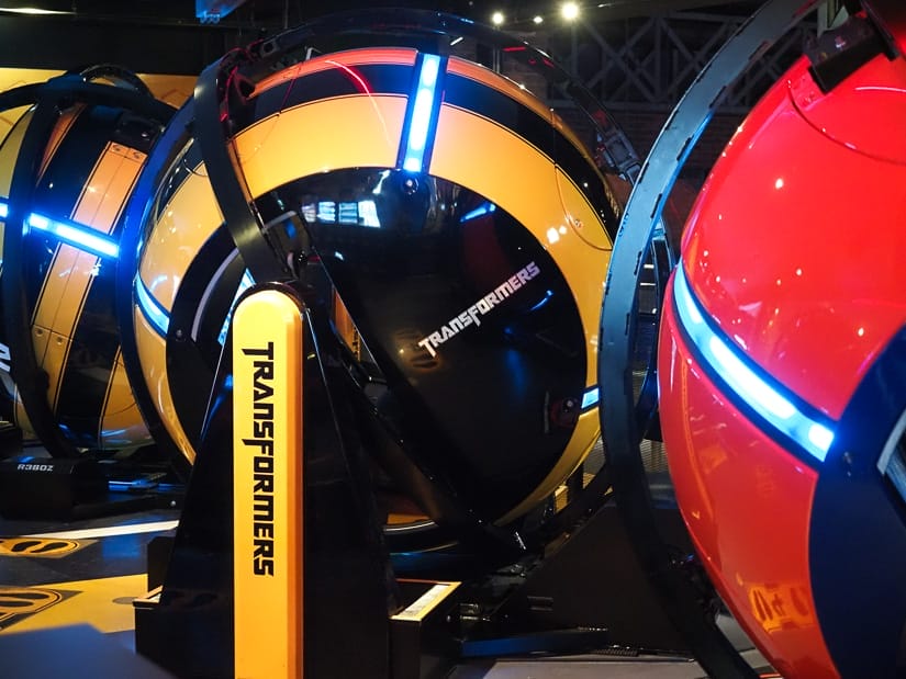 Some large spinning pods, two yellow and one red, with the word Transformers on the side