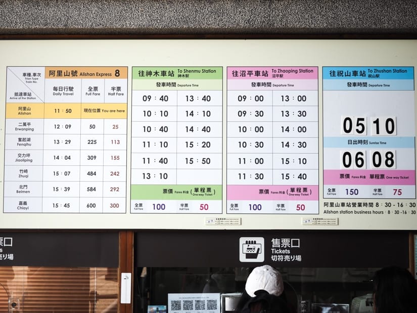 Photo of Alishan station ticket booth with signs above it showing all the departing train times on various lines