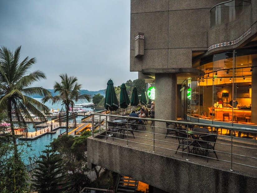 A second floor Starbucks patio on the right, overlooking a pier at Sun Moon lake on the left