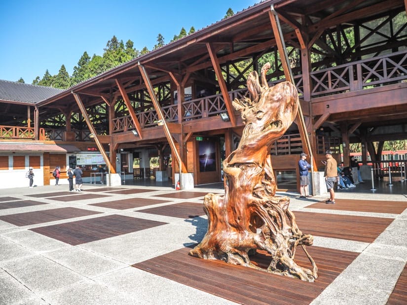 A large wooden statue in front of Alishan Train Station