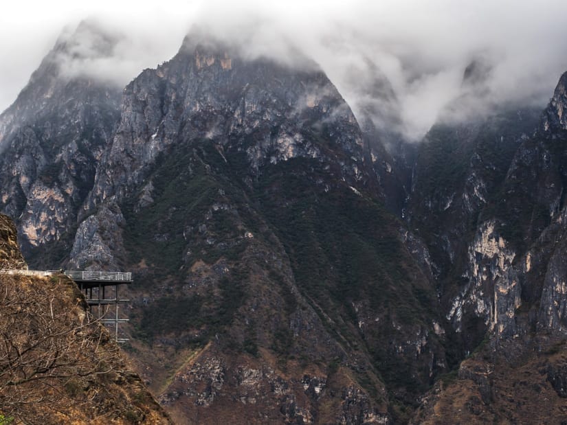 Wide view of Tiger Leaping Gorge with a lookout platform on the far left side