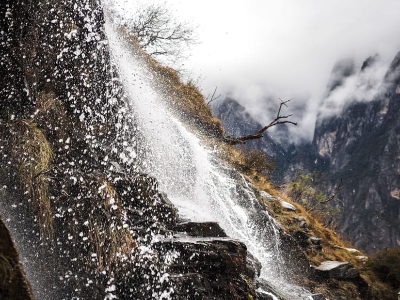 Close up shot from the side of a waterfall, with droplets of water suspended in the air