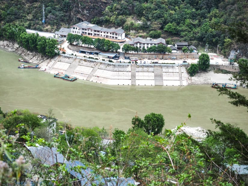 Zoomed in photo of the river running through Tiger Leaping Gorge with some boat launches on the far side
